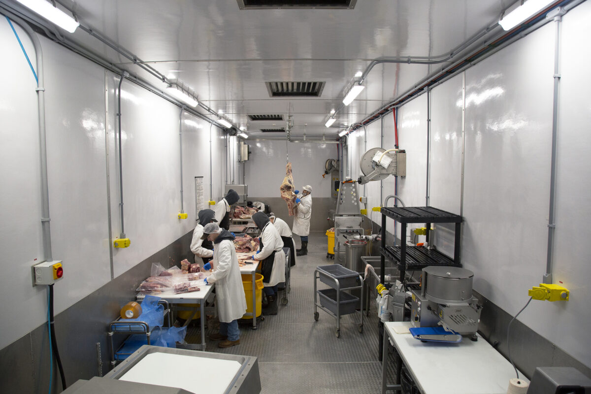 A team of butchers break down a beef carcass in the Cut and Package Module of a Friesla Meat Processing System.
