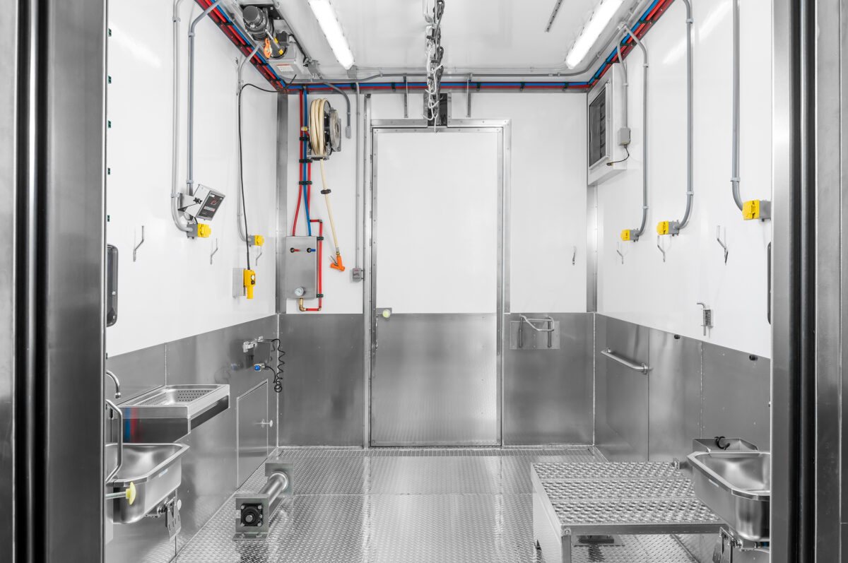 Harvest room of a Friesla Modular Meat Harvest Unit with diamond plate floor, aluminum skirted walls and washdown proof outlets.