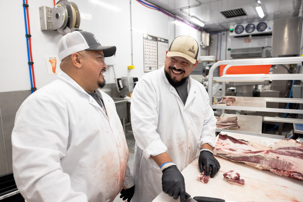 Smiling MTX Beef butchers fabricate and breakdown beef carcasses on polytop cutting tables in their Friesla Cut & Wrap Module.