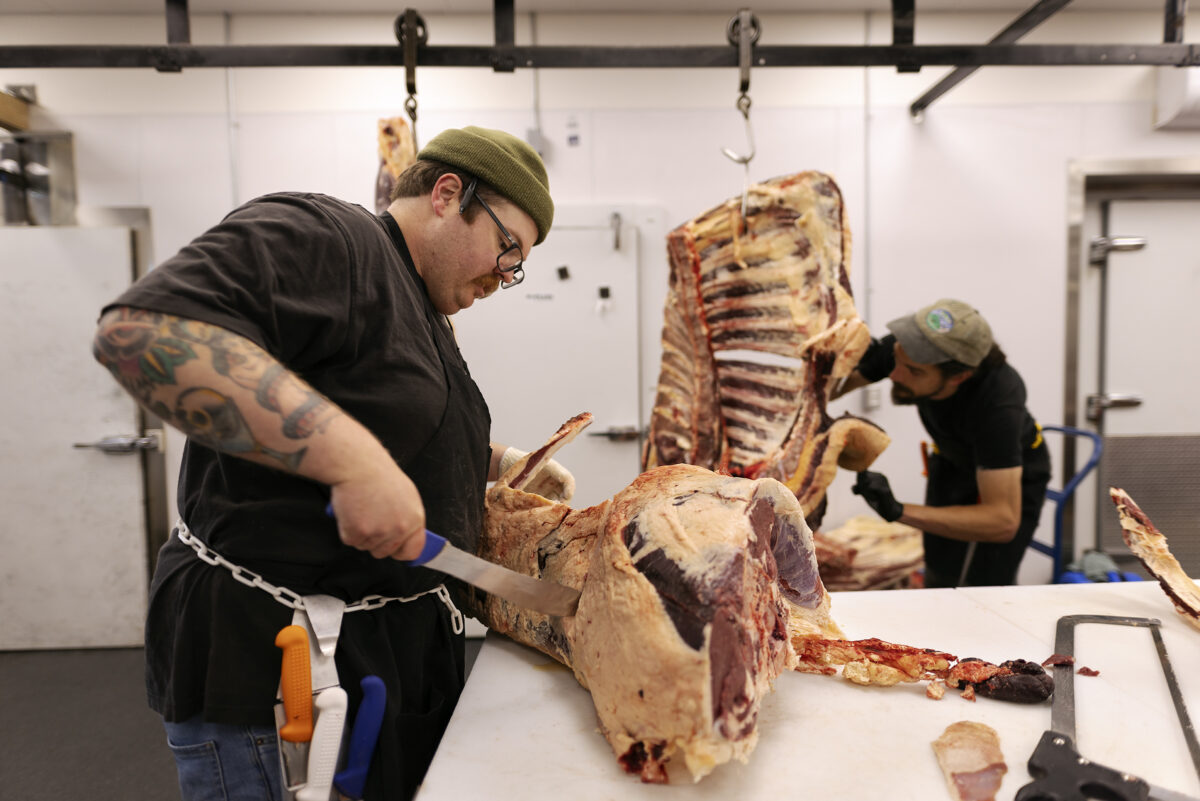 Butcher fabricates a beef carcass on a polytop cutting table.