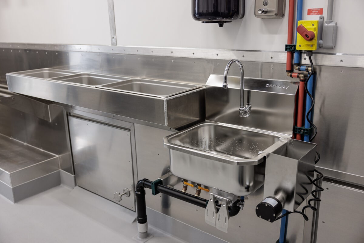 The knee-operated sink and removable inspection trays inside