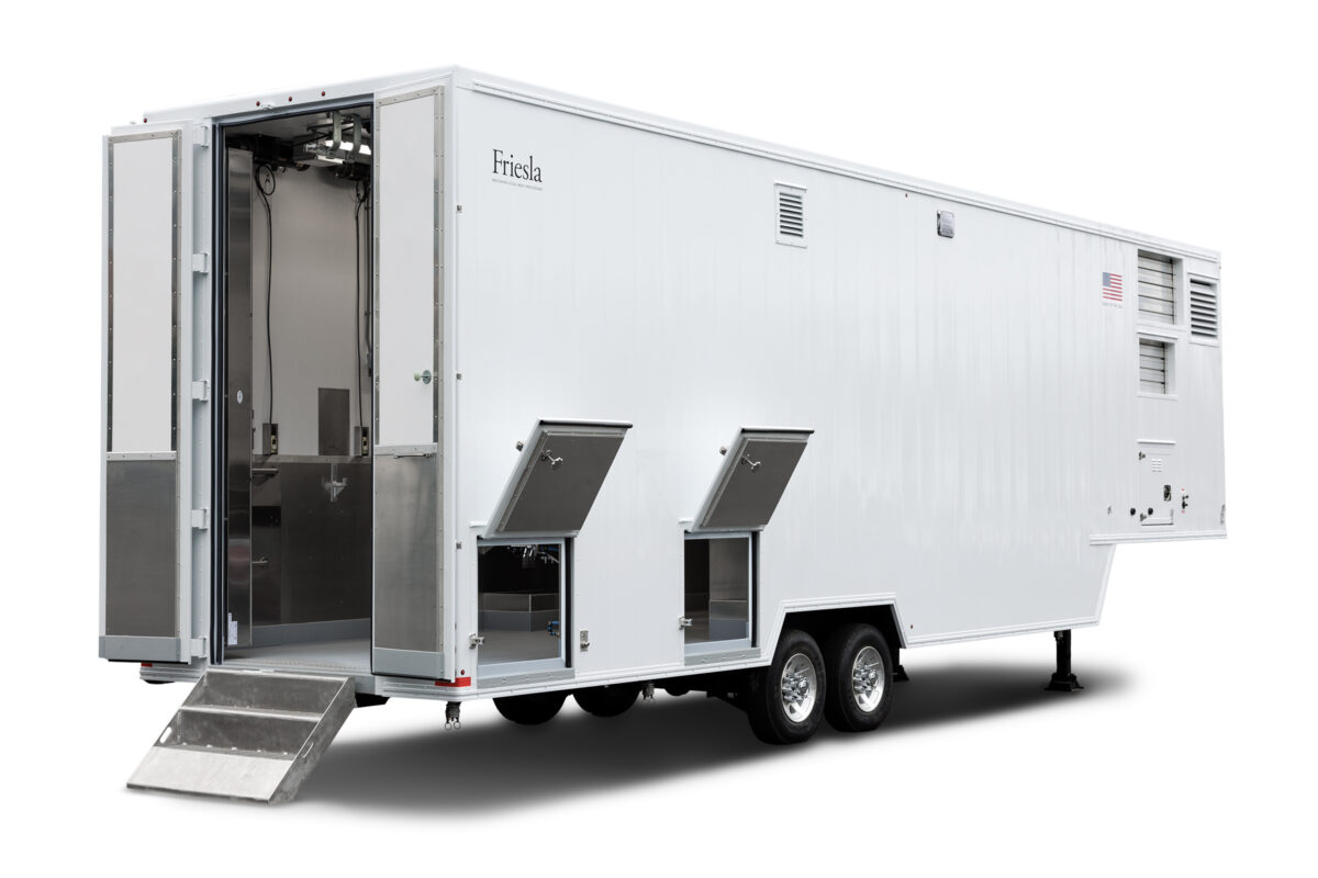 A rear view of a white, 38-foot-long Friesla Mobile Meat Harvest Unit used for on-site meat processing.